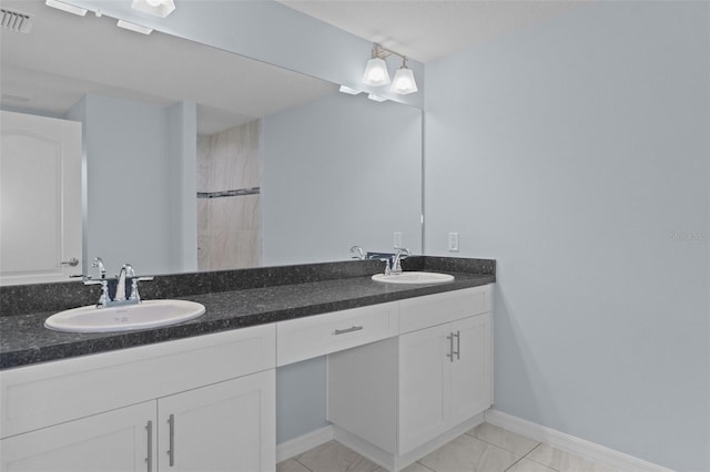 bathroom with a sink, visible vents, baseboards, and double vanity