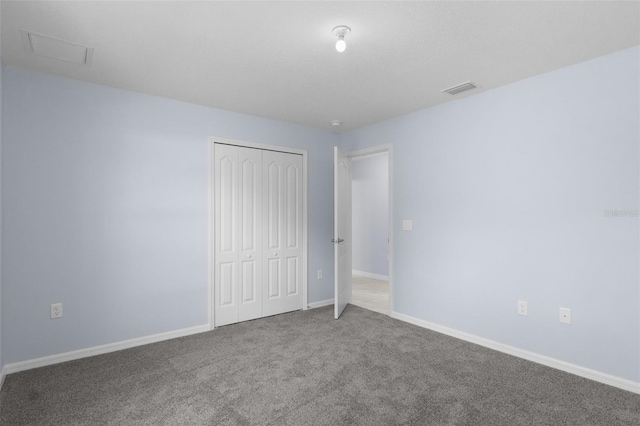 unfurnished bedroom featuring visible vents, baseboards, carpet, and a closet