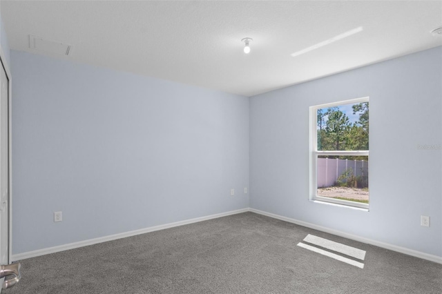 carpeted spare room featuring visible vents and baseboards