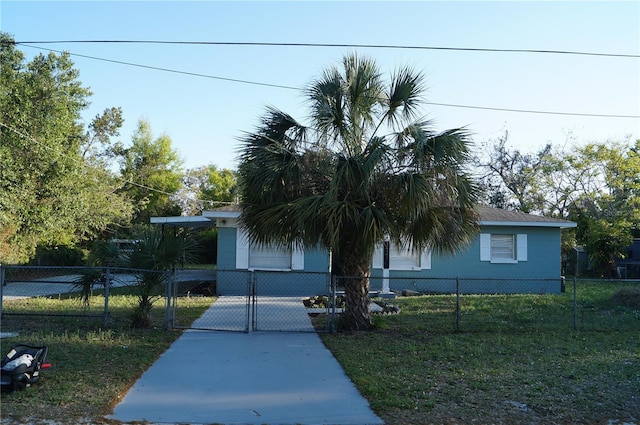 view of front of home with concrete driveway, a gate, and a fenced front yard