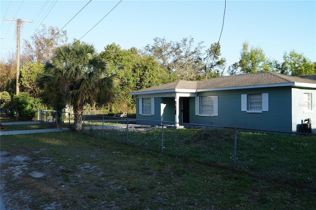 view of front of home with central AC unit, fence private yard, and a front yard