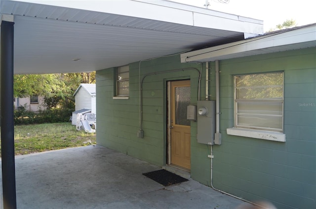 entrance to property featuring a carport and concrete block siding