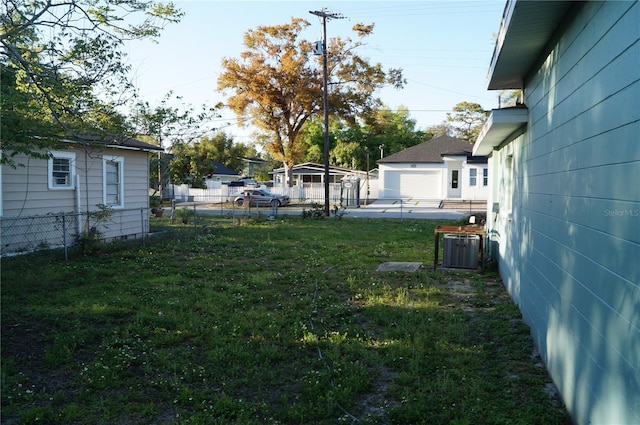 view of yard featuring central AC unit and fence