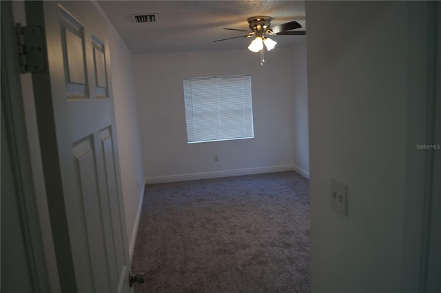 carpeted spare room with visible vents, baseboards, a textured ceiling, and ceiling fan