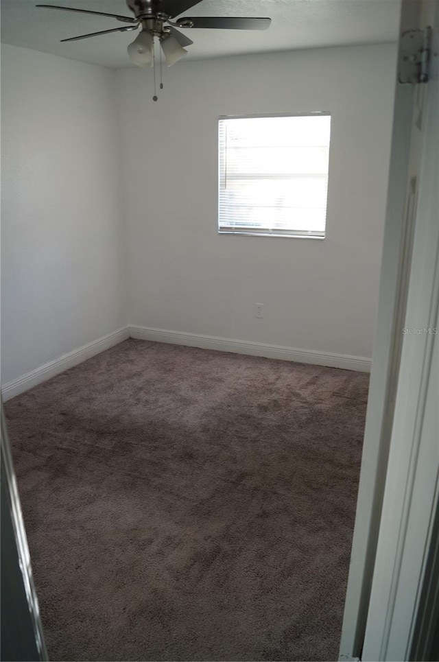 carpeted spare room with baseboards and ceiling fan