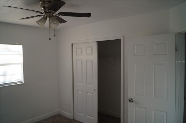 unfurnished bedroom with baseboards, a closet, and ceiling fan