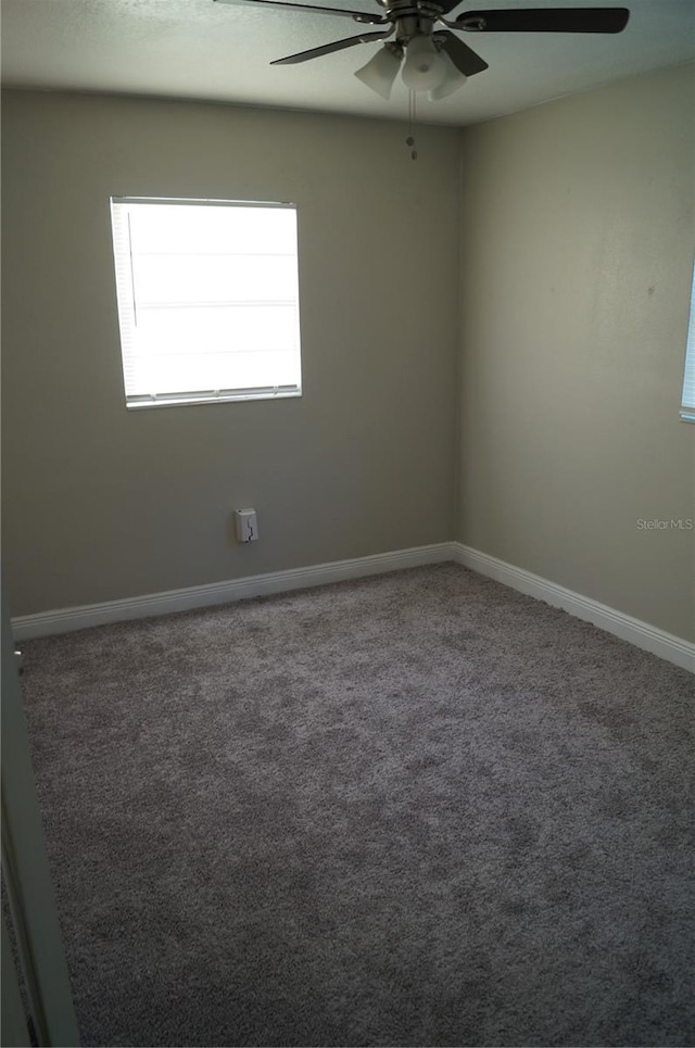 empty room with baseboards, carpet floors, and a ceiling fan