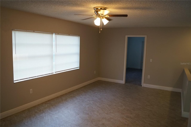 empty room with a textured ceiling, baseboards, and ceiling fan