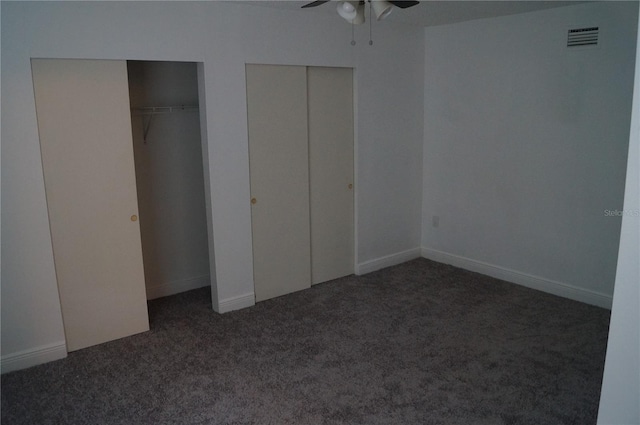 unfurnished bedroom featuring baseboards, carpet, visible vents, and multiple closets