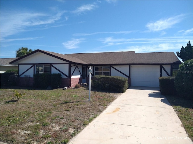 english style home featuring a shingled roof, concrete driveway, an attached garage, and stucco siding