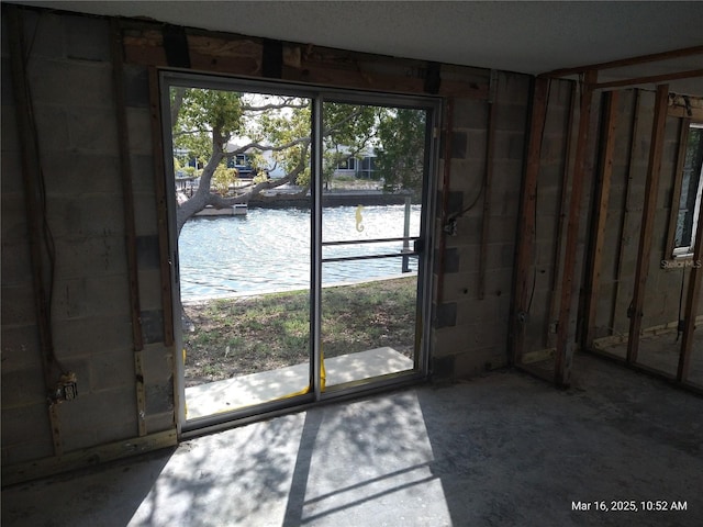 doorway featuring concrete block wall and a water view