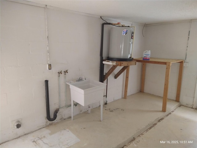 unfinished below grade area with a sink, concrete block wall, and electric water heater