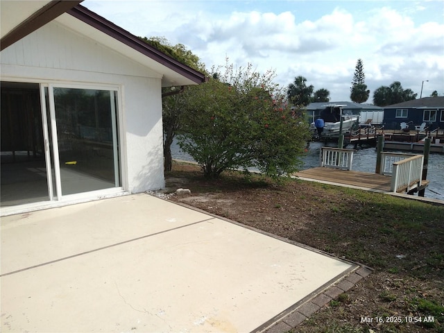 view of patio with a dock and a water view