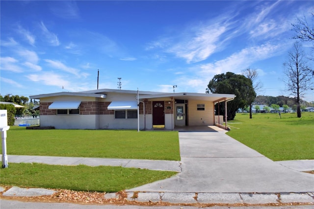 view of front facade featuring an attached carport, concrete driveway, and a front lawn