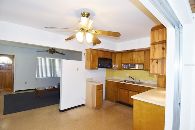 kitchen with a sink, brown cabinets, ceiling fan, and black microwave