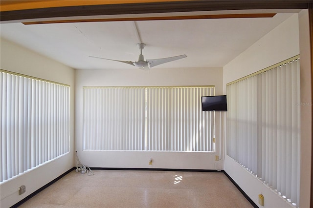 spare room featuring baseboards and a ceiling fan