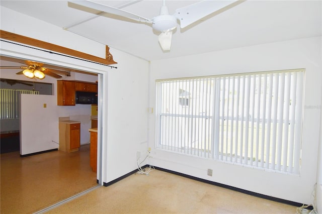 empty room featuring baseboards and ceiling fan