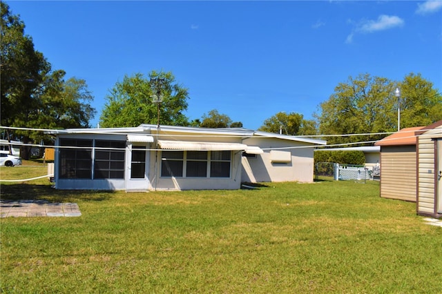 rear view of house featuring a lawn and stucco siding