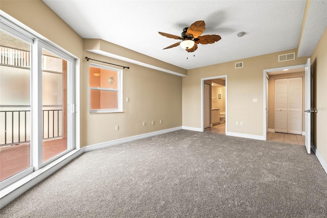 unfurnished bedroom featuring multiple windows, visible vents, and carpet floors