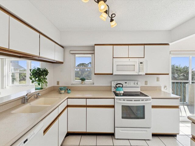 5557 Sea Forest Dr Unit 318, New Port Richey, FL 34652 - kitchen featuring white cabinetry, light countertops, a sink, and white appliances