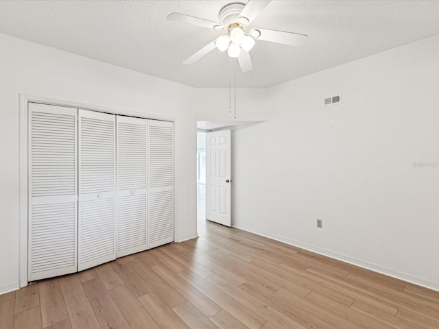 5557 Sea Forest Dr Unit 318, New Port Richey, FL 34652 - unfurnished bedroom with visible vents, a closet, light wood-type flooring, and a textured ceiling