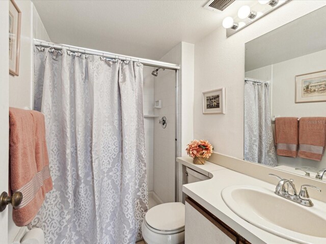 5557 Sea Forest Dr Unit 318, New Port Richey, FL 34652 - full bath with toilet, vanity, curtained shower, and visible vents