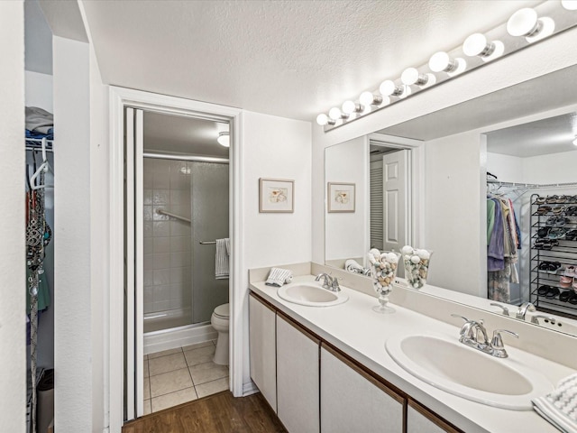 5557 Sea Forest Dr Unit 318, New Port Richey, FL 34652 - bathroom featuring toilet, a sink, a shower stall, and a textured ceiling