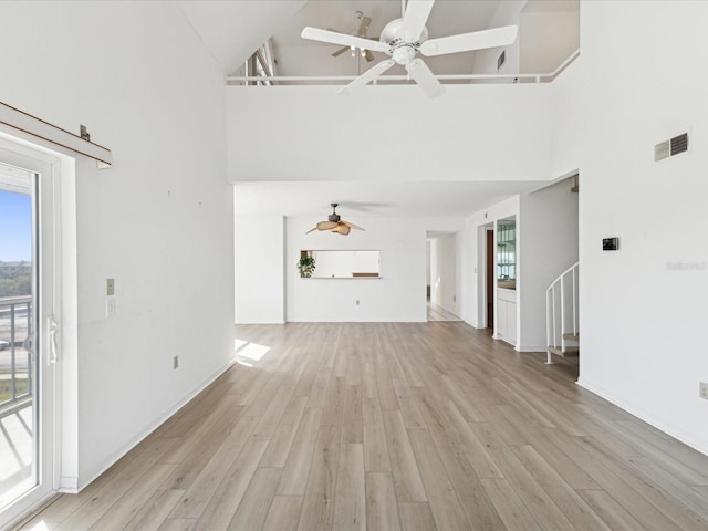 5557 Sea Forest Dr Unit 318, New Port Richey, FL 34652 - unfurnished living room featuring a ceiling fan, visible vents, a towering ceiling, and light wood-type flooring