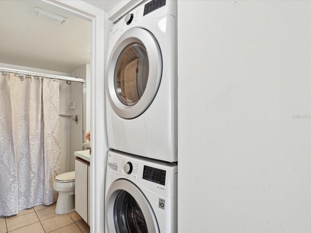 5557 Sea Forest Dr Unit 318, New Port Richey, FL 34652 - laundry room featuring visible vents, stacked washer / drying machine, laundry area, and light tile patterned floors