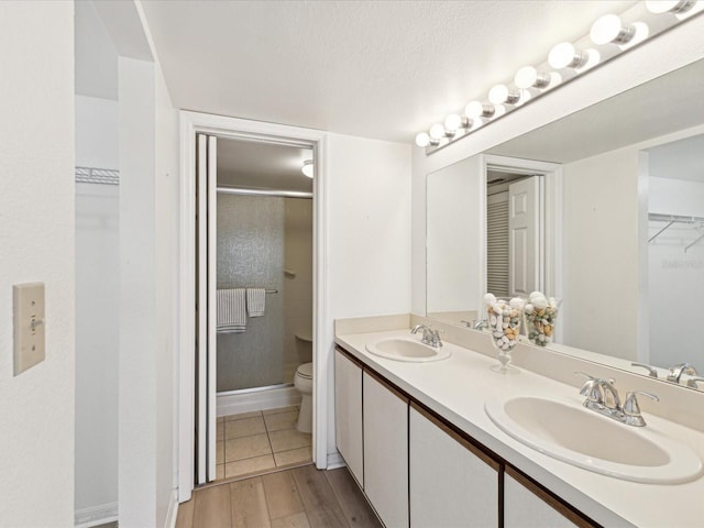 5557 Sea Forest Dr Unit 318, New Port Richey, FL 34652 - bathroom featuring a shower stall, double vanity, toilet, and a sink