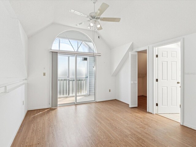 5557 Sea Forest Dr Unit 318, New Port Richey, FL 34652 - unfurnished living room featuring baseboards, lofted ceiling, ceiling fan, and wood finished floors
