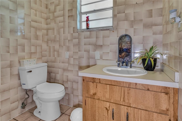 bathroom featuring toilet, tile walls, vanity, and tile patterned flooring