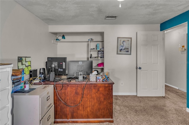 carpeted office space featuring visible vents, baseboards, and a textured ceiling