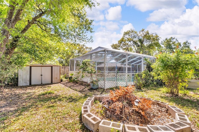 view of yard with an outbuilding, an outdoor pool, a shed, and a lanai