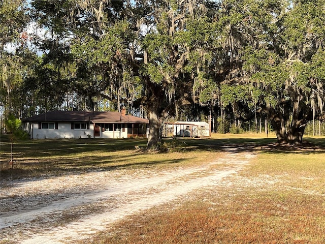 single story home featuring a front yard, driveway, and a detached carport