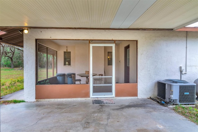 view of patio featuring a sunroom and central AC