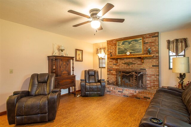 living room with wood finished floors, ceiling fan, a fireplace, and baseboards