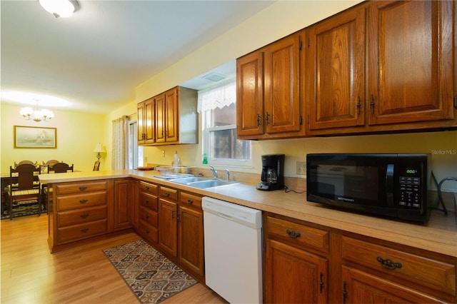 kitchen featuring white dishwasher, light countertops, a chandelier, a peninsula, and black microwave