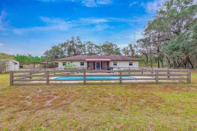 back of house with a yard, fence, a fenced in pool, and stucco siding