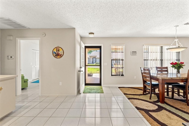 dining area with light tile patterned floors, visible vents, and a wealth of natural light