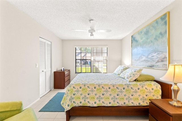 tiled bedroom featuring a closet, a textured ceiling, and ceiling fan