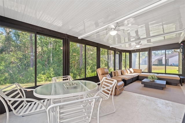sunroom featuring outdoor dining space, a ceiling fan, and an outdoor hangout area
