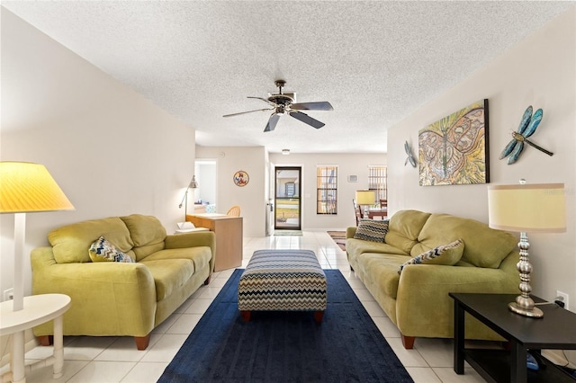 living area featuring a textured ceiling, light tile patterned floors, and ceiling fan