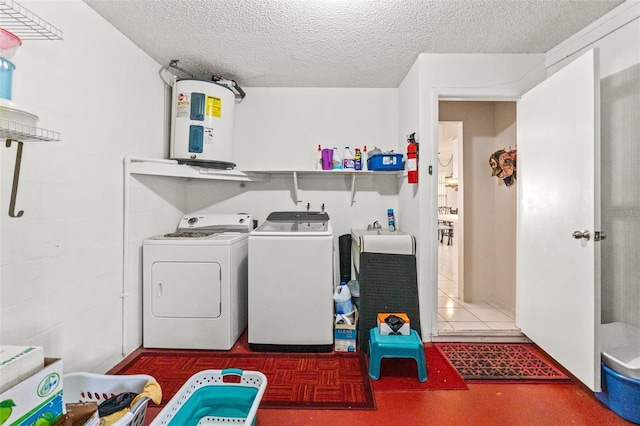 washroom with a textured ceiling, laundry area, independent washer and dryer, and electric water heater