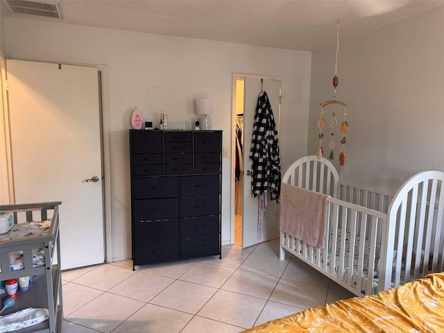 5249 Courtland Rd, Spring Hill, FL 34608 - bedroom featuring light tile patterned floors, visible vents, and a crib