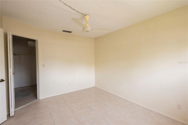 empty room with visible vents, baseboards, a textured ceiling, and ceiling fan
