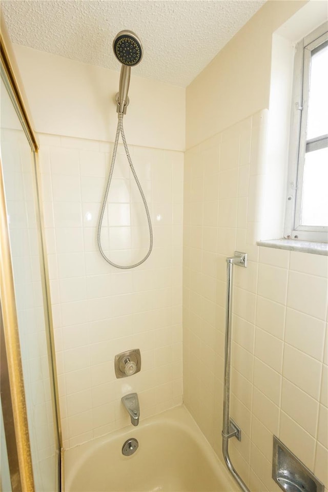 bathroom featuring a textured ceiling and shower / washtub combination