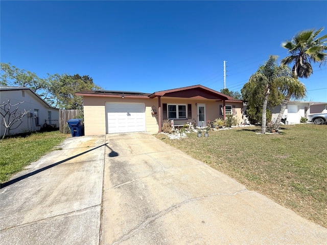 view of front of home with a front lawn, concrete driveway, fence, and a garage