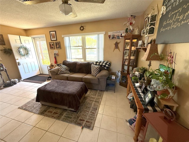 living room featuring light tile patterned floors, a textured ceiling, and ceiling fan