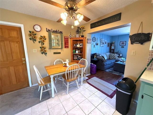 dining room featuring light tile patterned floors, a ceiling fan, and a textured ceiling